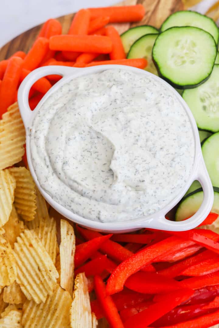 Dill Dip on serving board with veggies and chips.