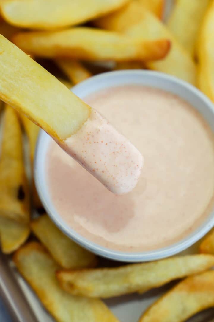 closeup of fry being dipped in fry sauce.