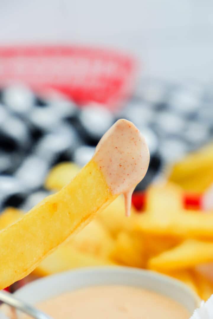 closeup of French fry with Fry Sauce on it.