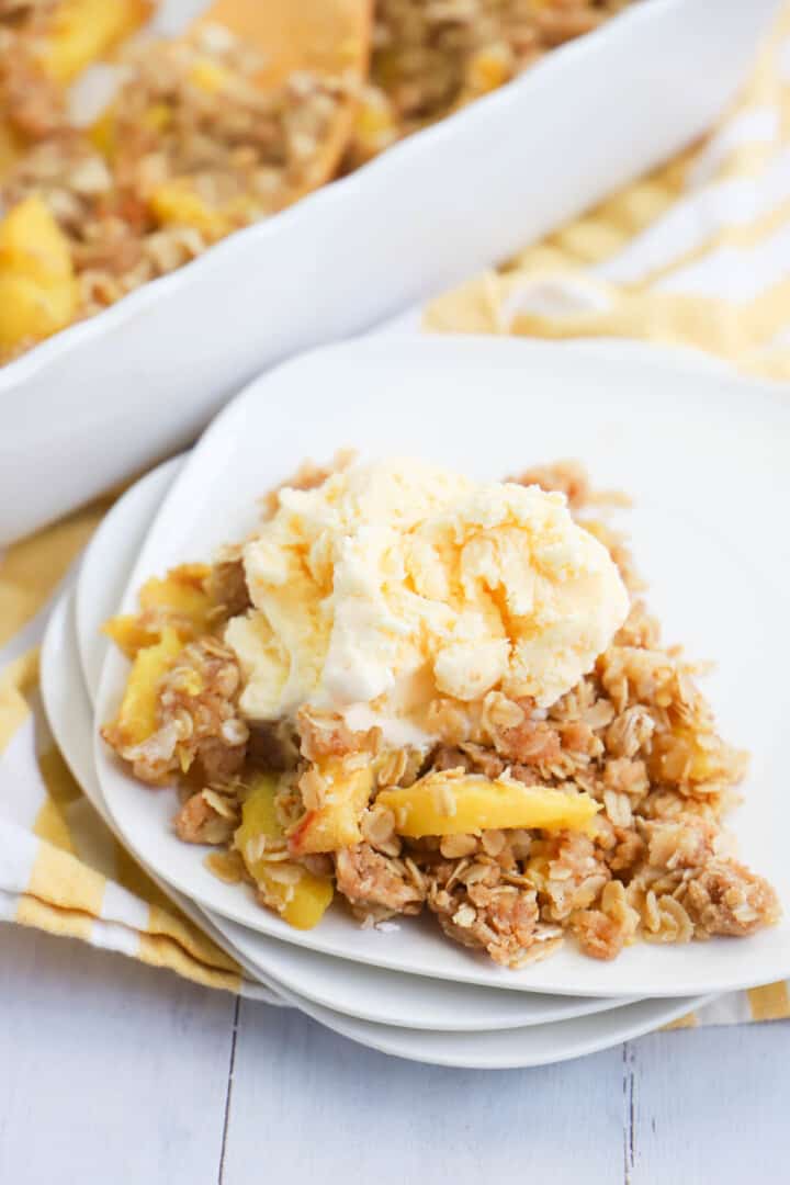 closeup of peach crisp on white plates.