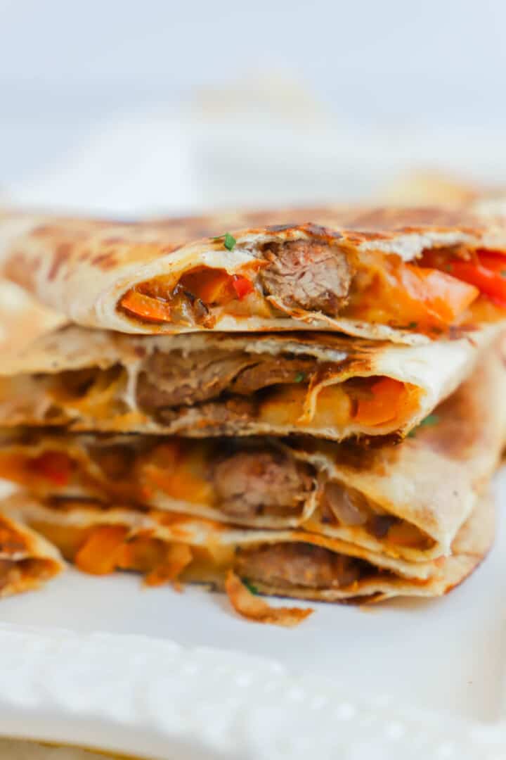 Steak Quesadillas stacked on white serving plate.