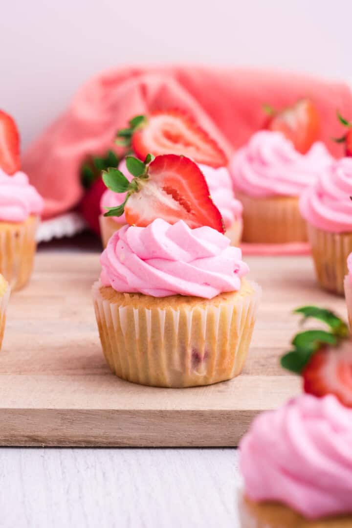 Strawberry Cupcakes on wooden serving board.