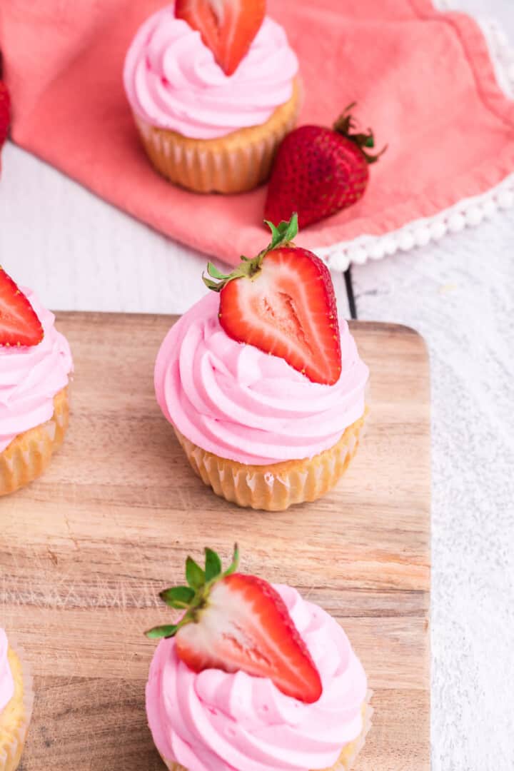 Strawberry Cupcakes on wooden serving board.