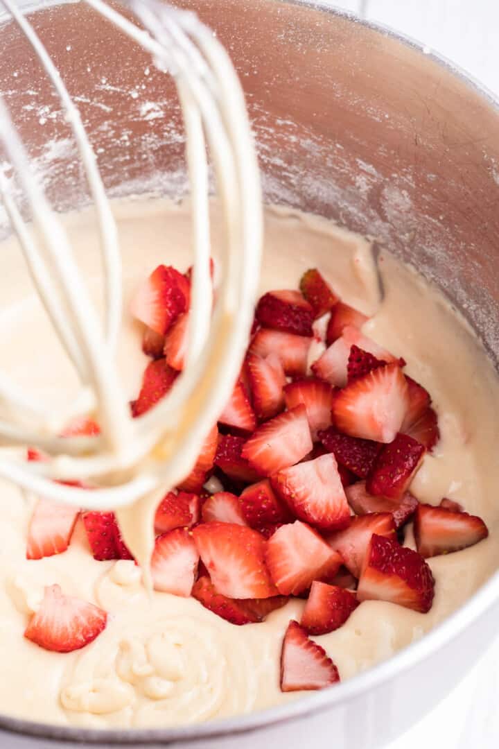 adding fresh strawberry chunks to the cupcake batter.