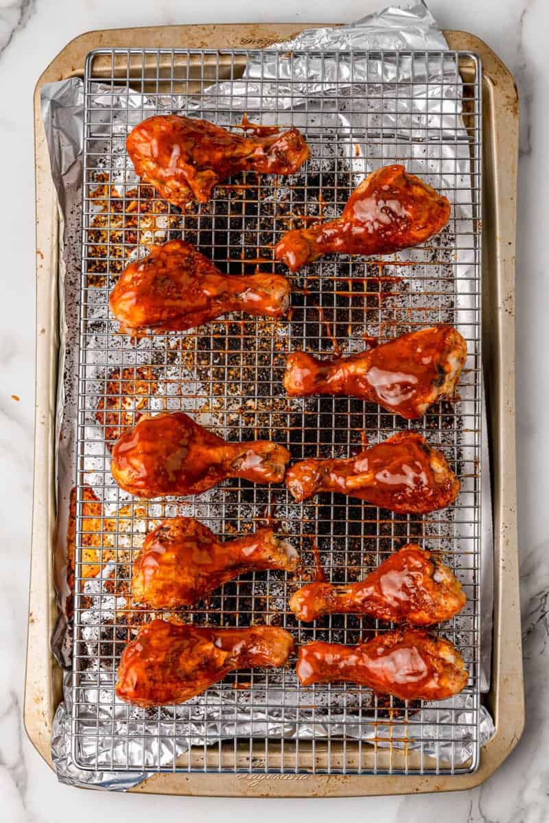 baked BBQ chicken drumsticks covered in BBQ sauce.