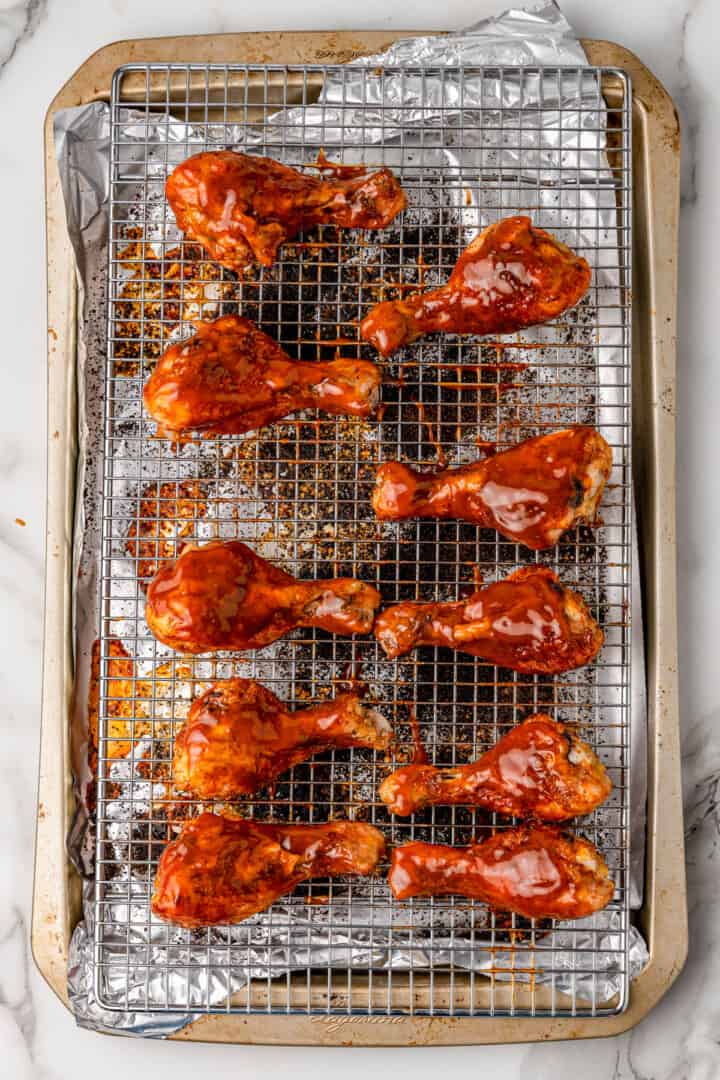baked BBQ chicken drumsticks covered in BBQ sauce.