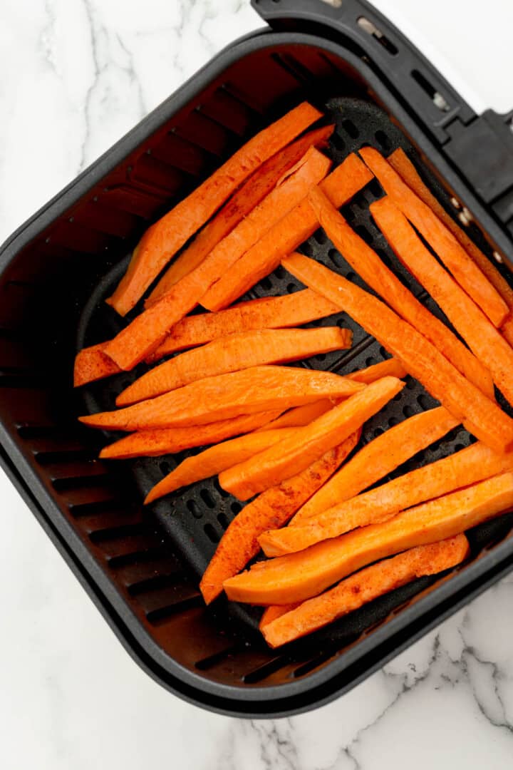 sweet potato fries in air fryer basket.