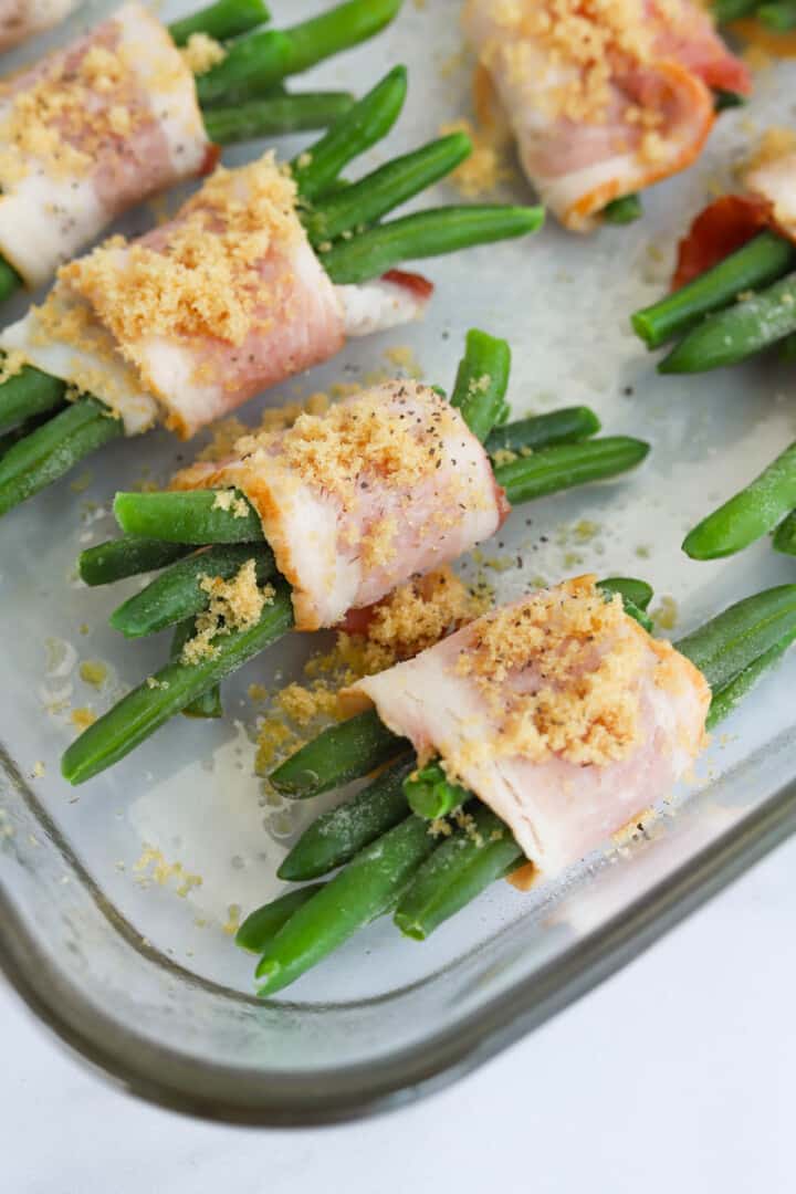 Bacon wrapped green beans in baking dish before cooking.