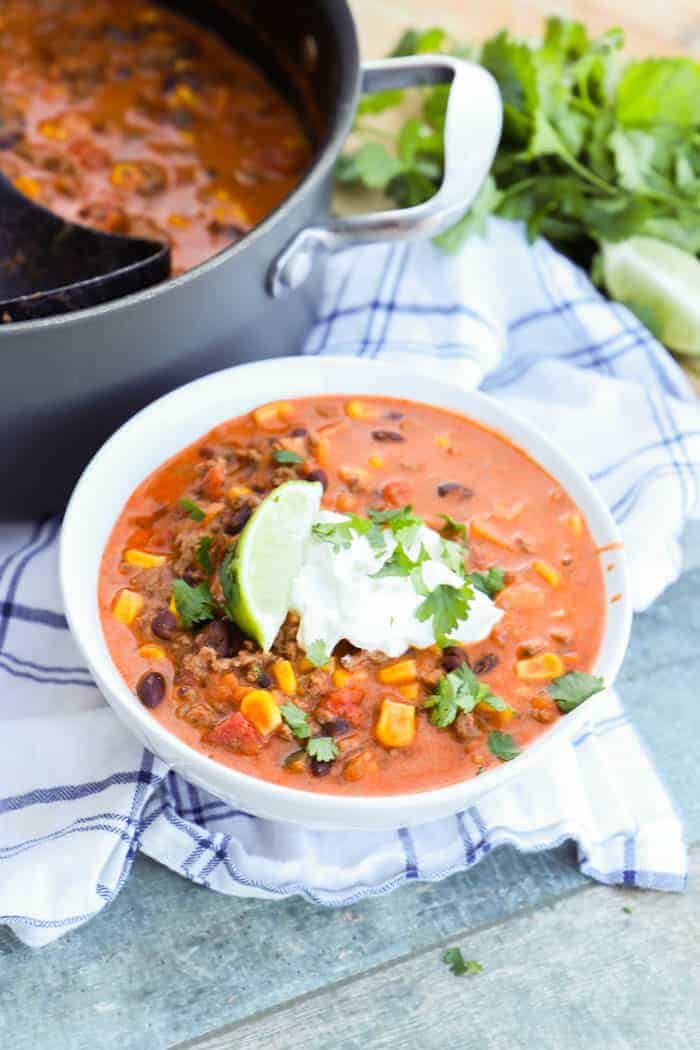 Creamy Taco Soup in white bowl topped with sour cream.