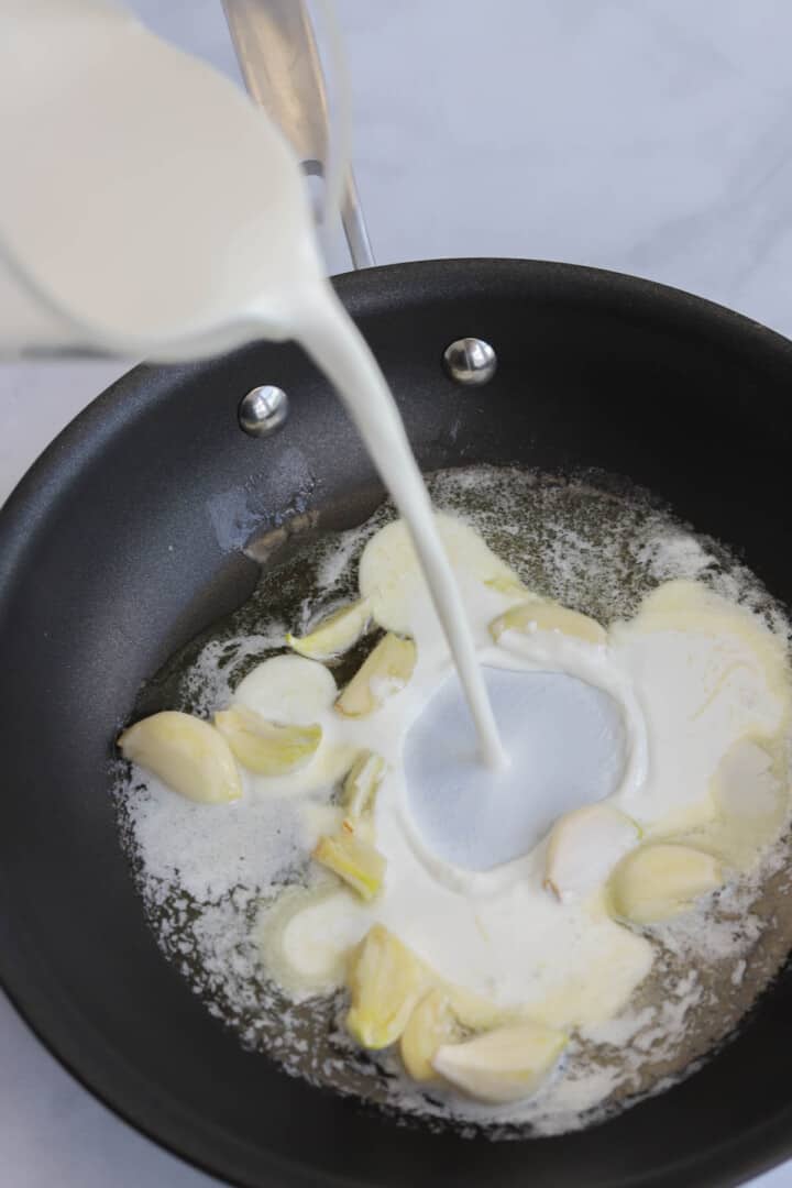 adding half and half to the garlic.