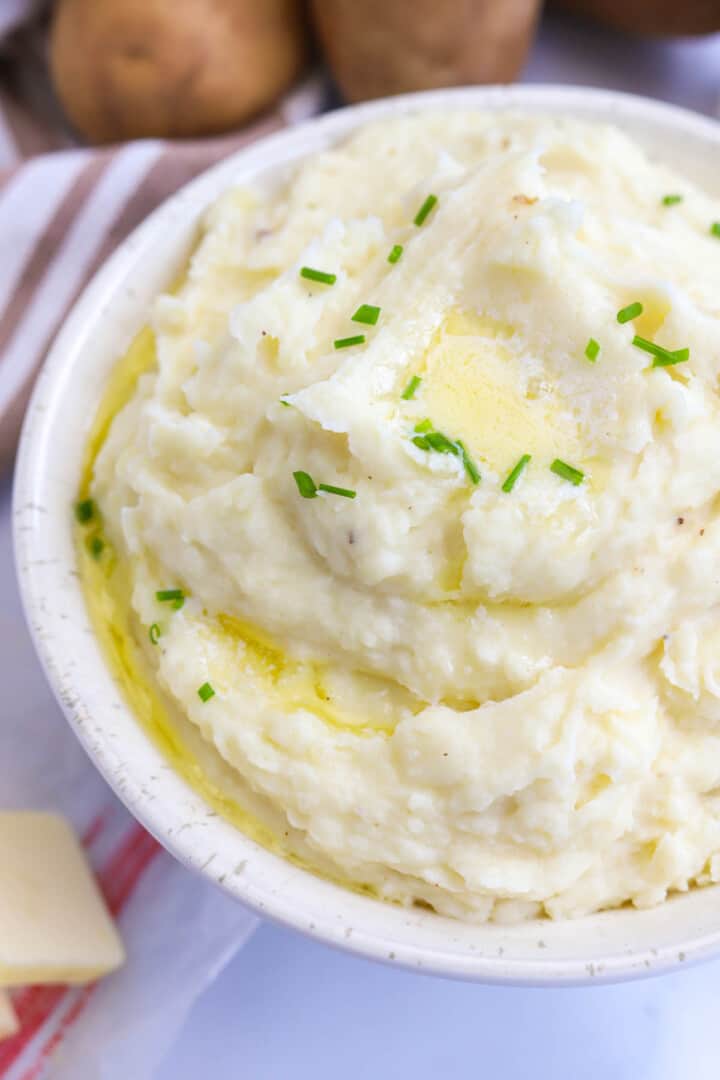closeup of garlic mashed potatoes in white bowl.