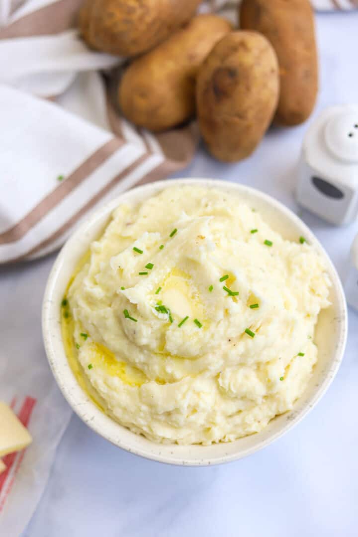 Garlic Mashed Potatoes in white bowl topped with butter.