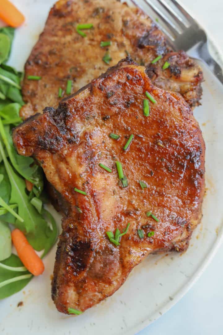cooked pork chops on white plate.