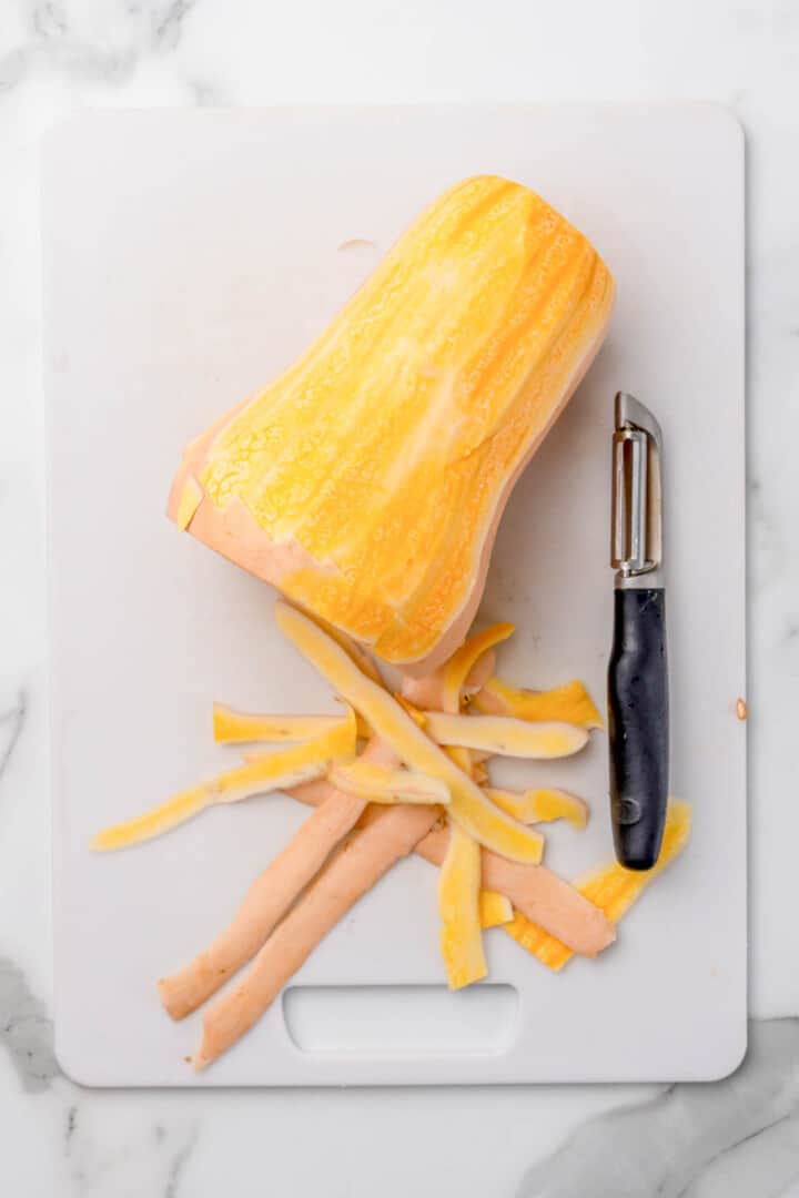 Female hands making butternut squash noodles with a vegetable peeler.Top  view Stock Photo - Alamy