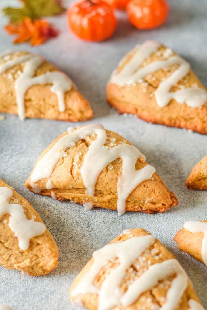 Pumpkin Scones on counter topped with sugar and icing.
