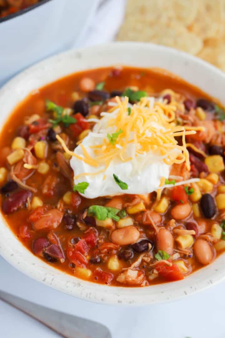 closeup of taco soup topped with sour cream and cheese.