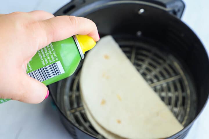 spraying the quesadilla with cooking spray.