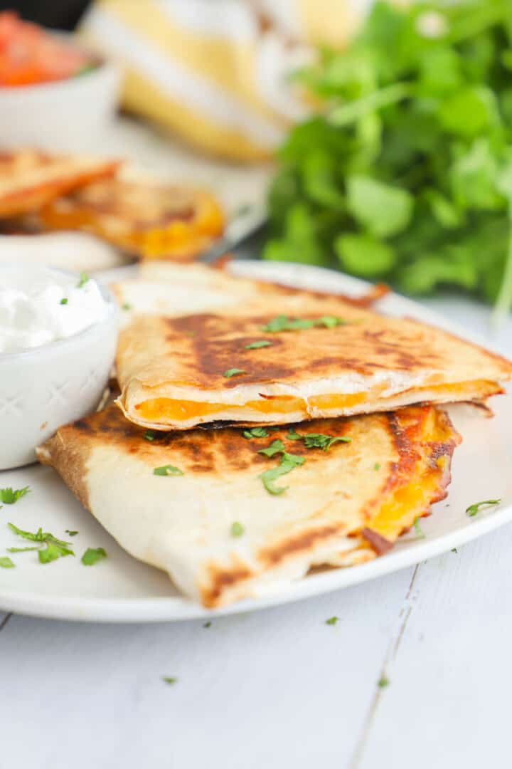 closeup of air fryer quesadillas on white plates.