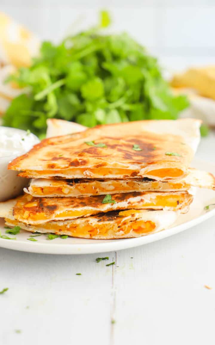 air fryer quesadillas stacked on white plates.