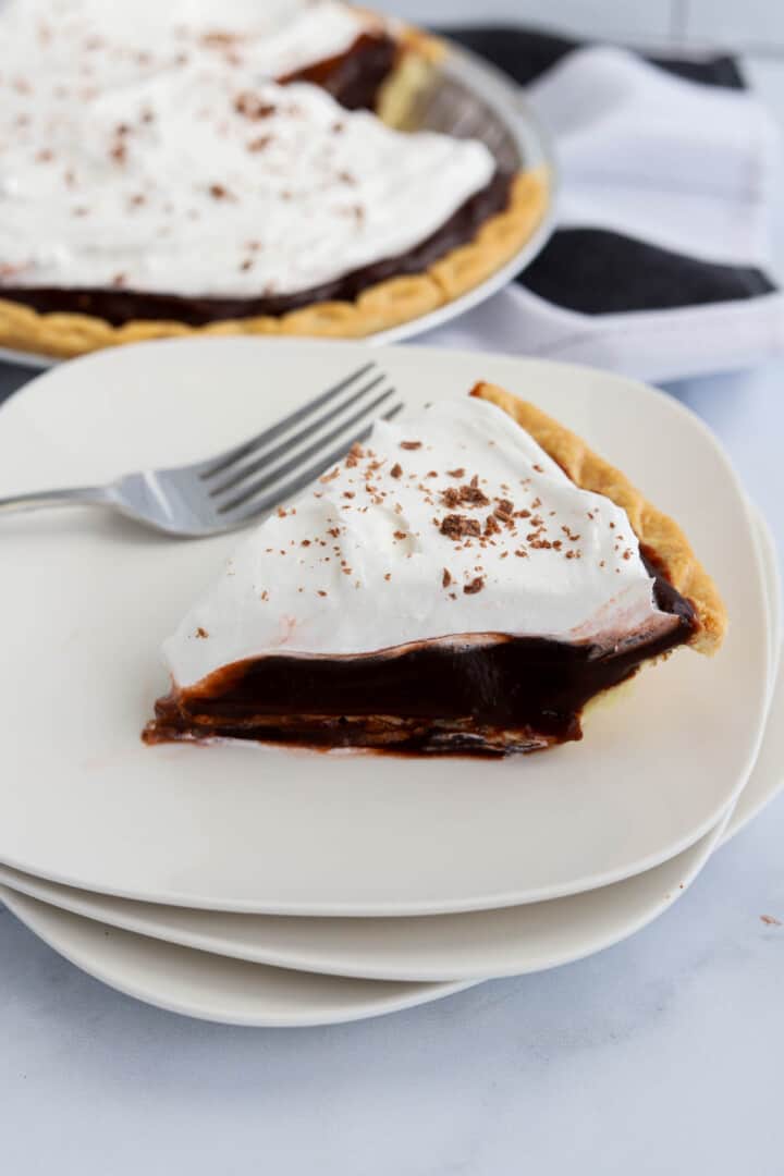 Chocolate Pudding Pie on stacked white plates.