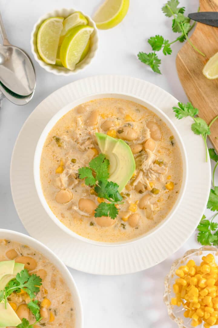 Slow Cooker Chicken Chili in white bowl topped with avocado slices.