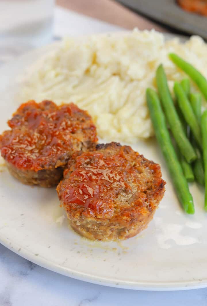 Mini Meatloaf served on white plate with mashed potatoes and green beans.