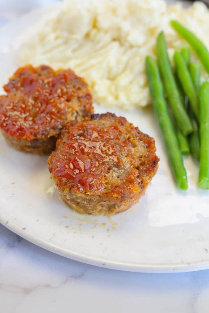 mini meatloaf served for dinner with mashed potatoes and green beans.