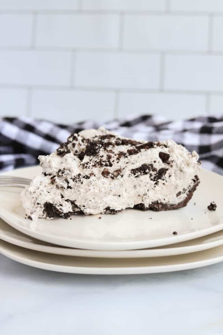 slice of Oreo Pie on stacked white plates.