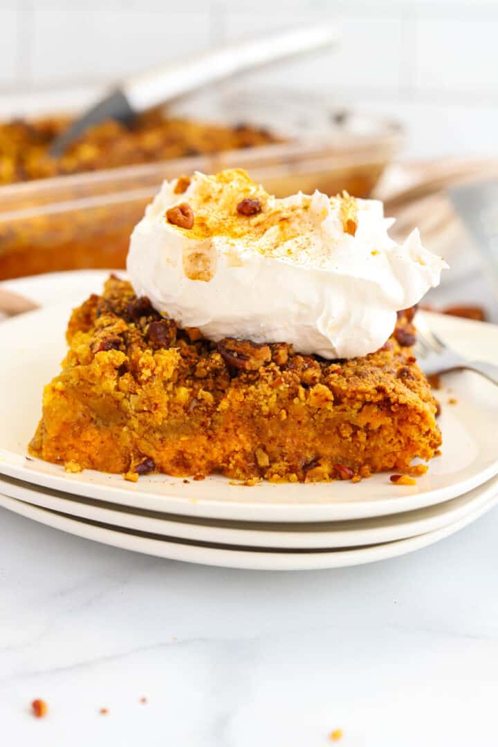 Pumpkin Crunch Cake on stacked white plates.