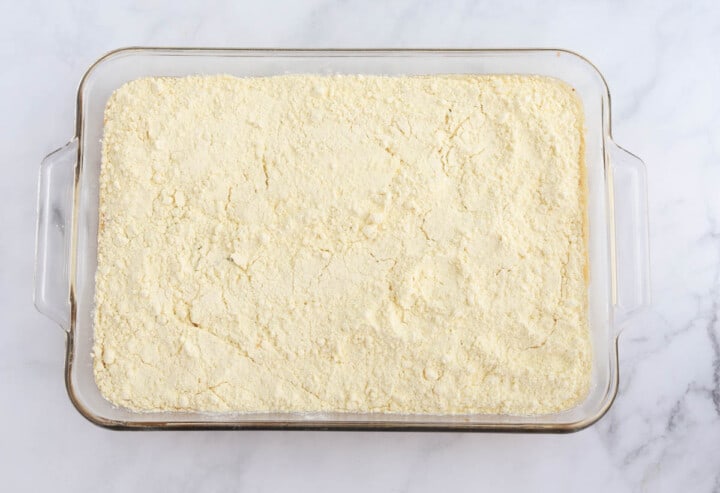covering the pumpkin pie mix with the cake mix.
