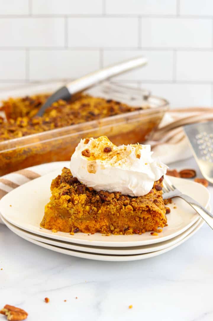 pumpkin crunch cake on stacked white plates.
