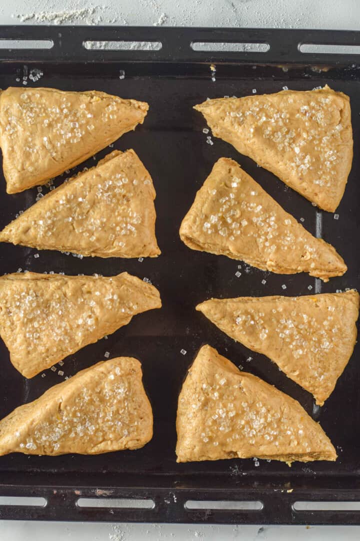 scones on baking sheet topped with sugar before baking.