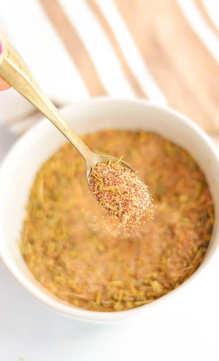 Turkey Seasoning being spooned out of a white bowl.