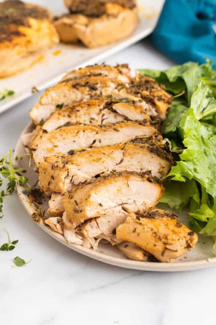sliced turkey breast on white plate with salad.