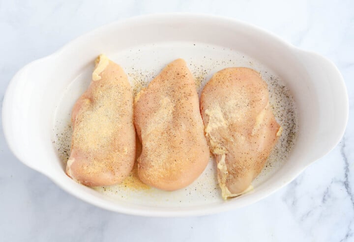 seasoning the chicken before baking.