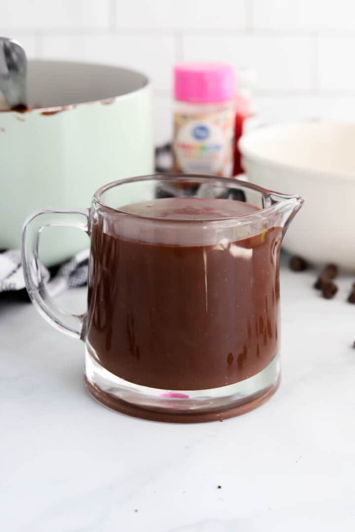 Homemade Hot Fudge Sauce in glass pouring cup.
