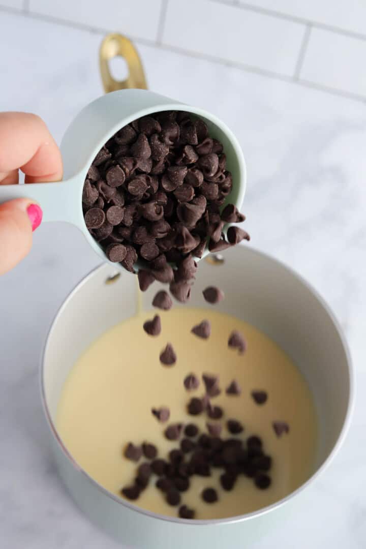 pouring the chocolate chips into the condensed milk.