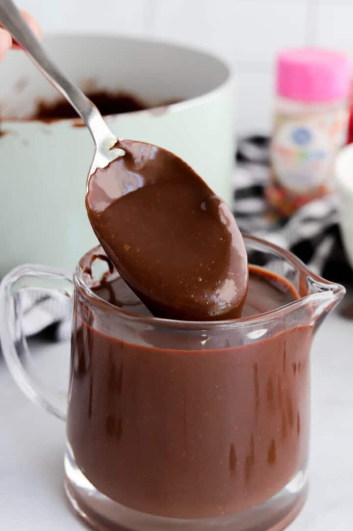 scooping the hot fudge with a spoon.