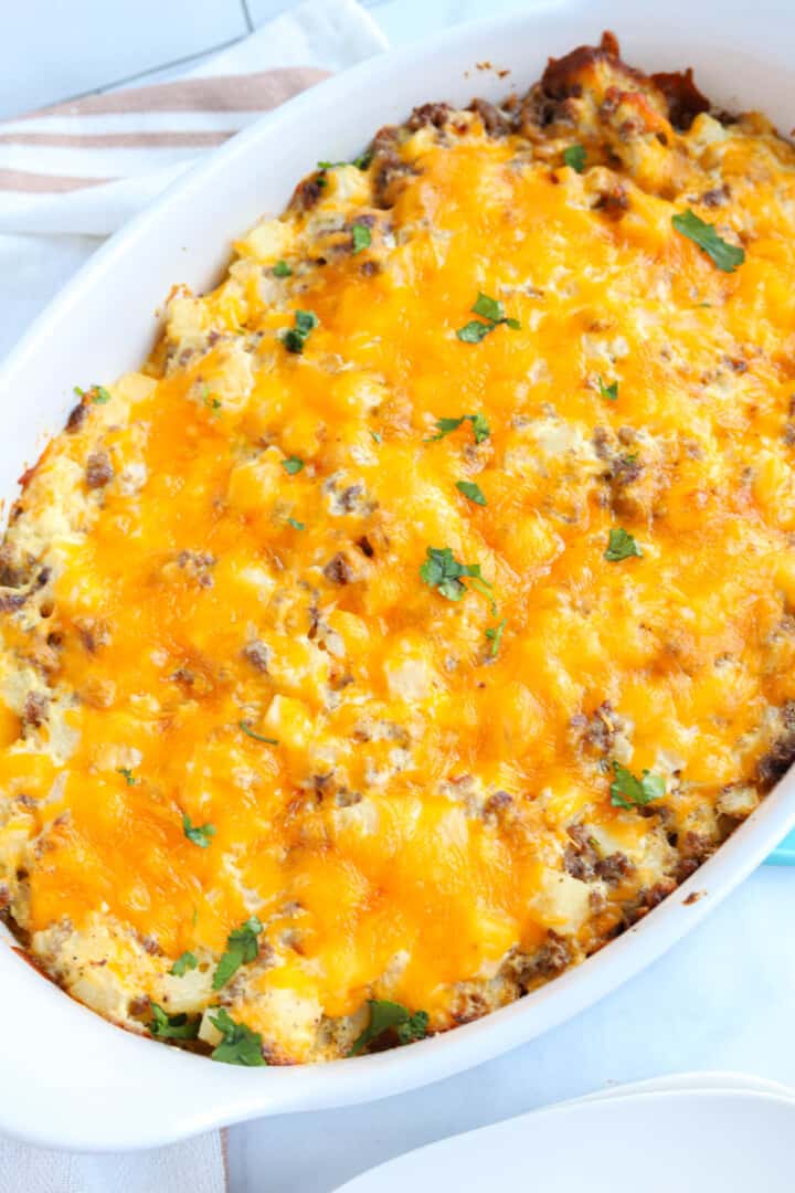 baked hamburger hashbrown casserole in white casserole dish.