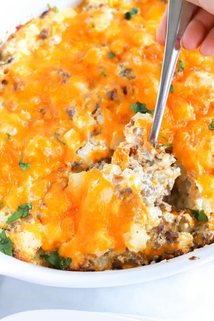 closeup of casserole being scooped with metal spoon.