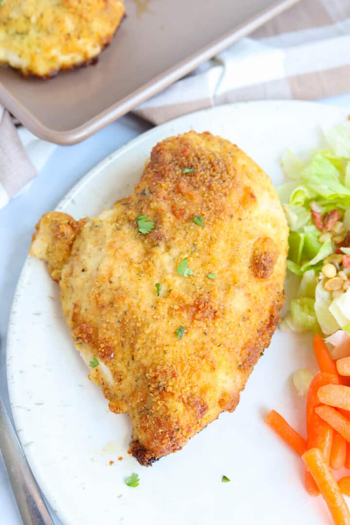ranch chicken on white plate with salad.