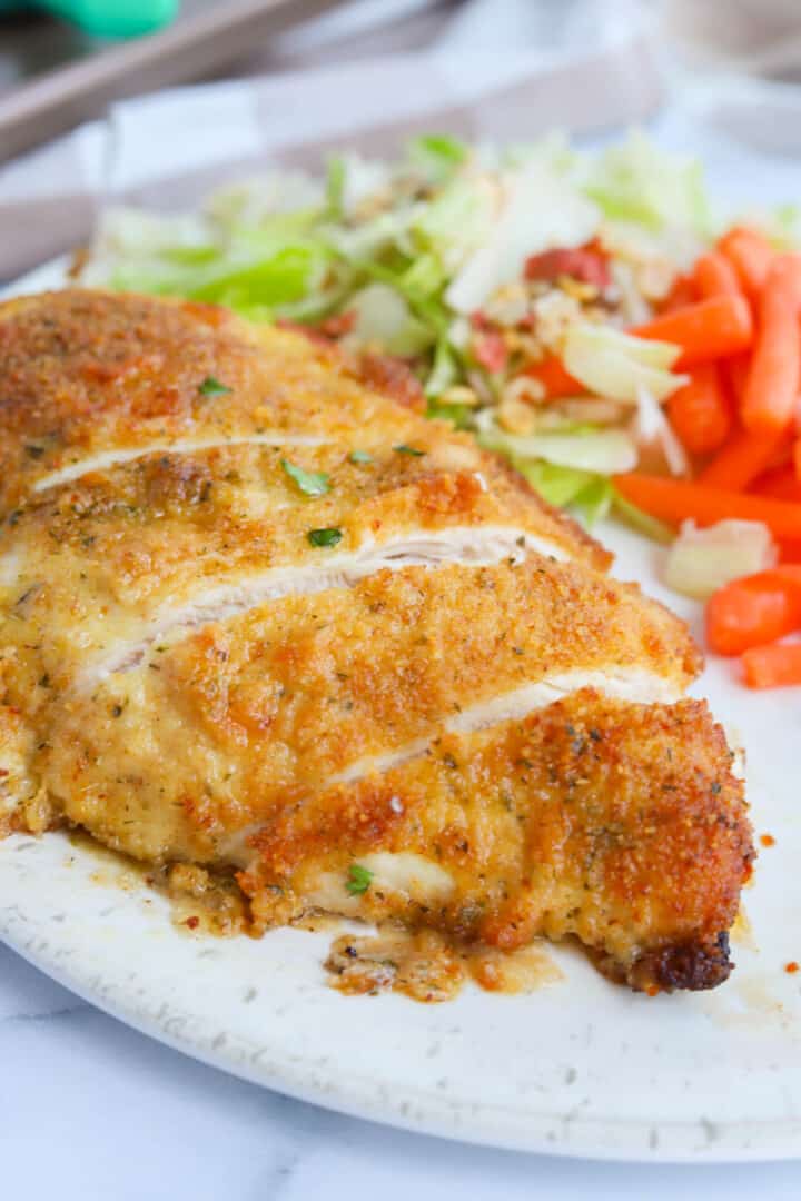 ranch chicken sliced on white plate with salad.