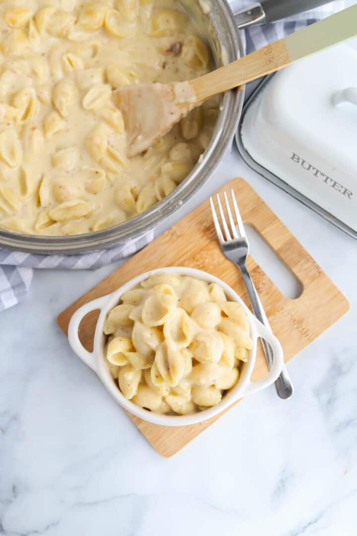 serving the mac and cheese in a white bowl.