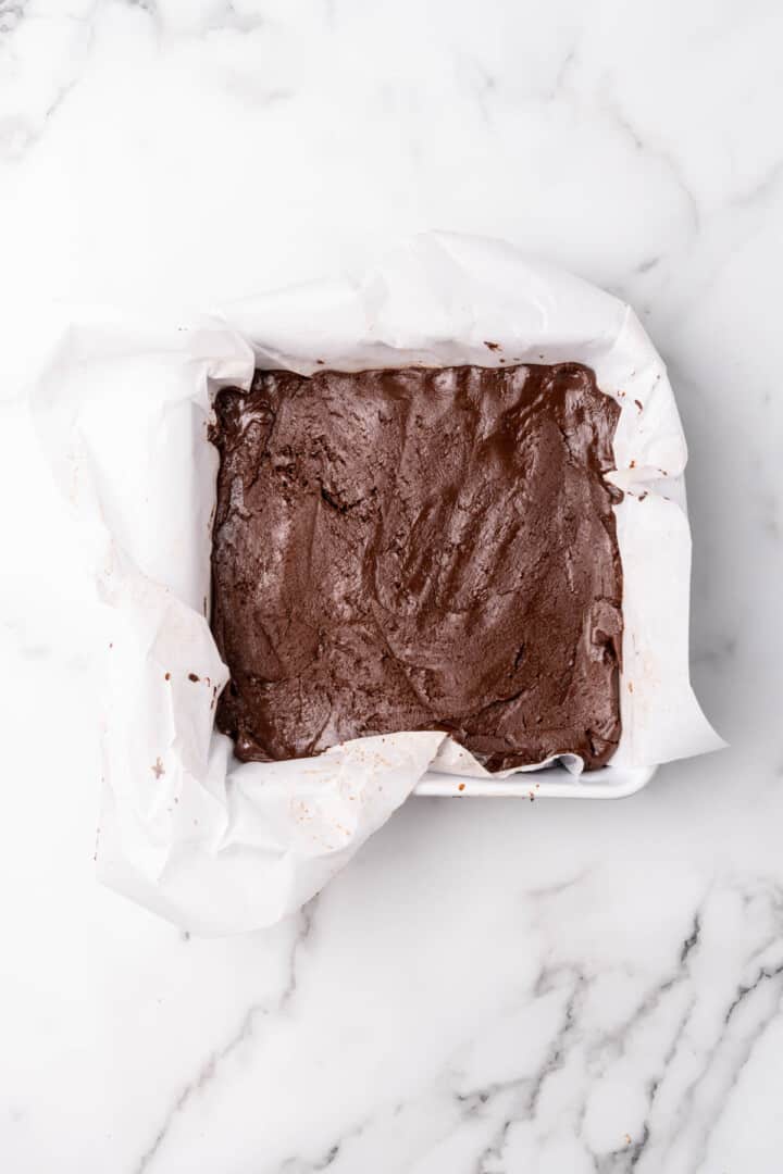 fudge added to square dish with parchment paper.