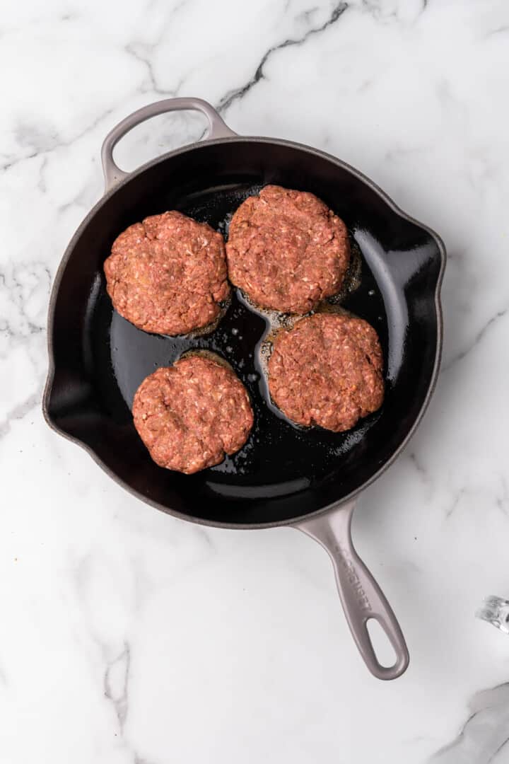 cooking the Salisbury steaks in a skillet.