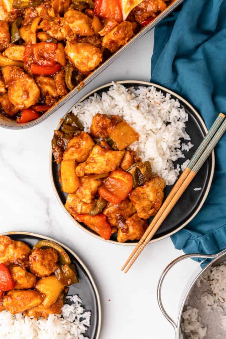 serving sweet and sour chicken on plates with rice.