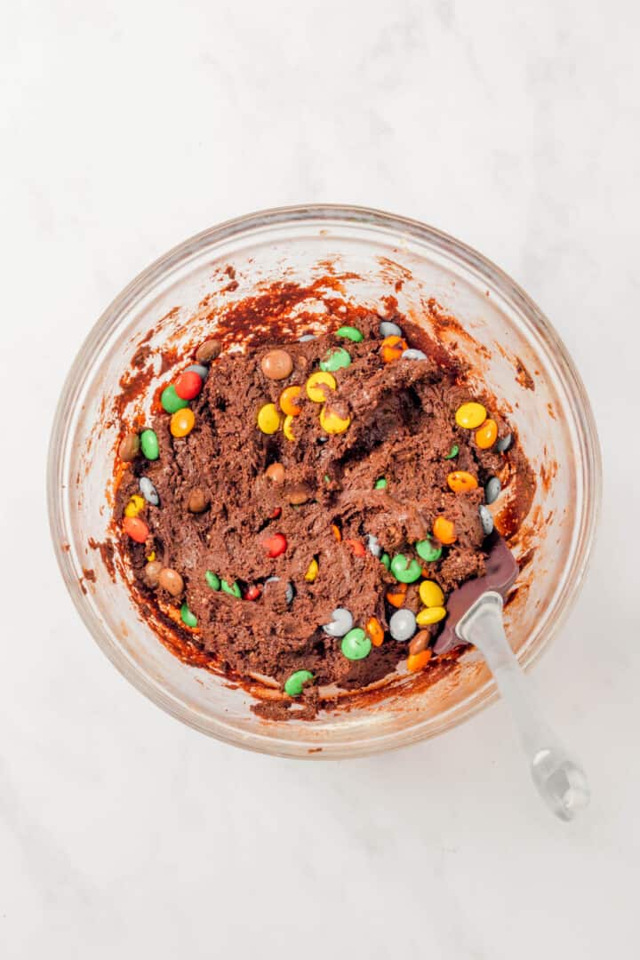mixing in the M&Ms to the cookie dough.