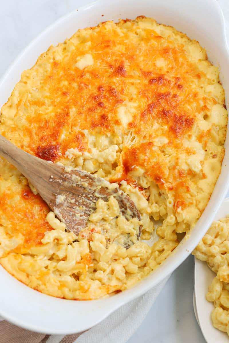 Four Cheese Mac and Cheese in baking dish with wooden spoon in it.