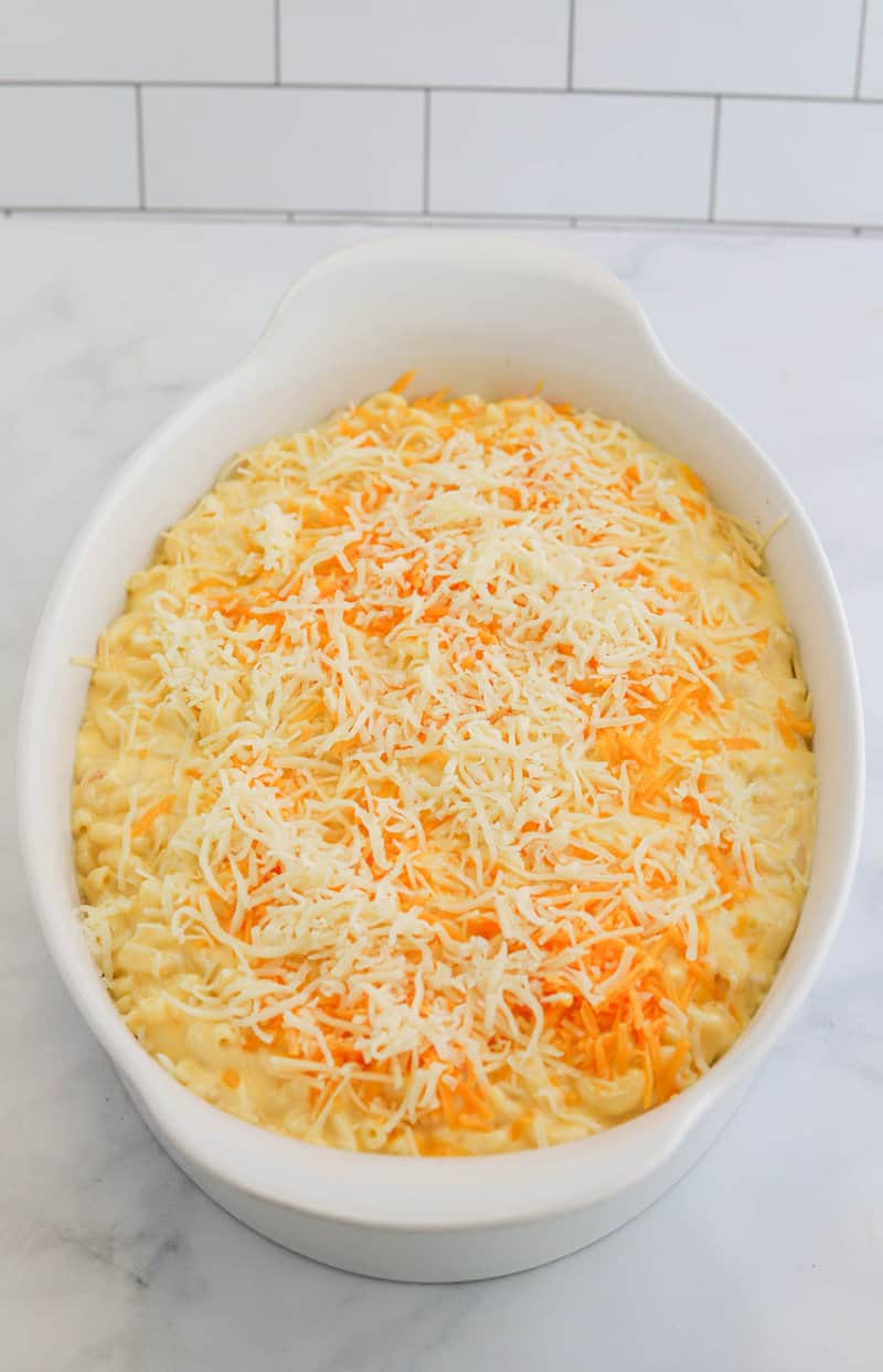 four cheese mac and cheese in baking dish topped with cheese.