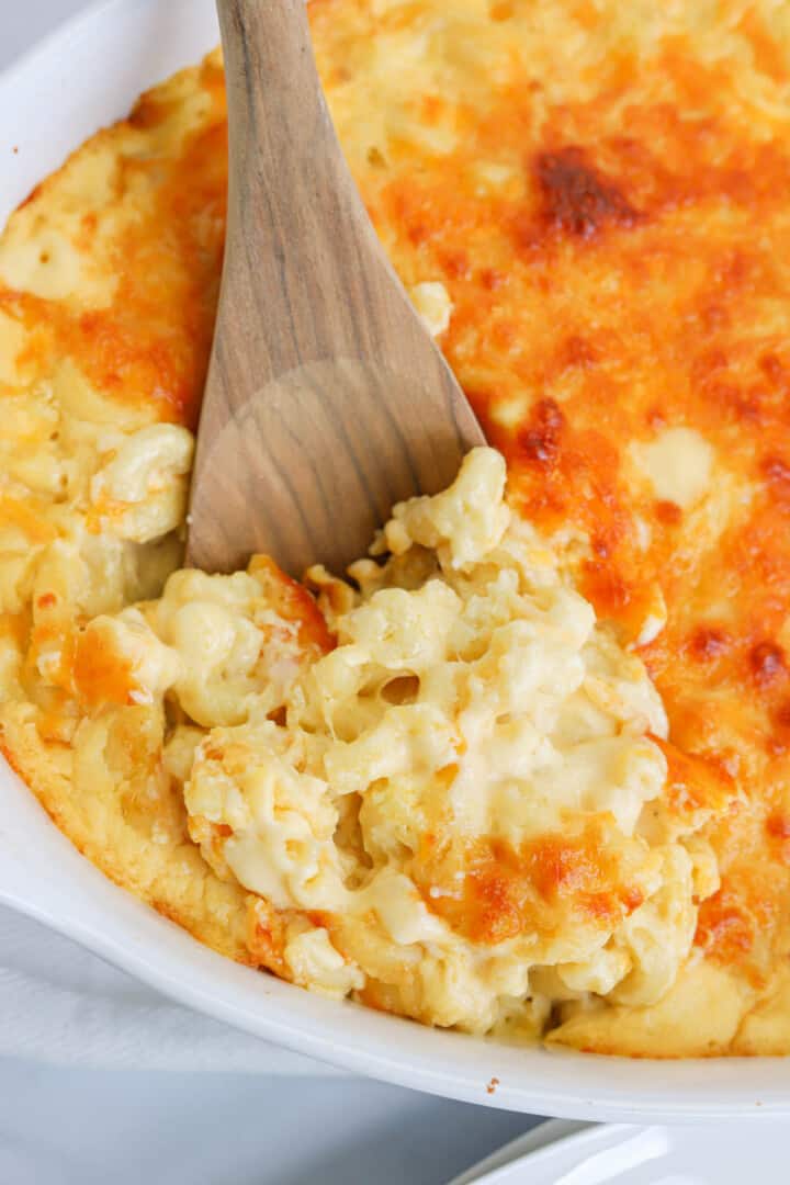 scooping mac and cheese out of the baking dish.